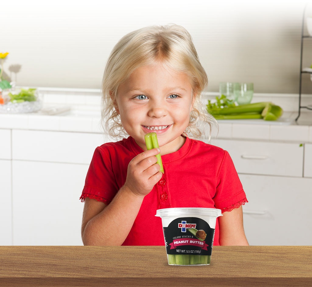 kid eating a celery and peanut butter snack cup